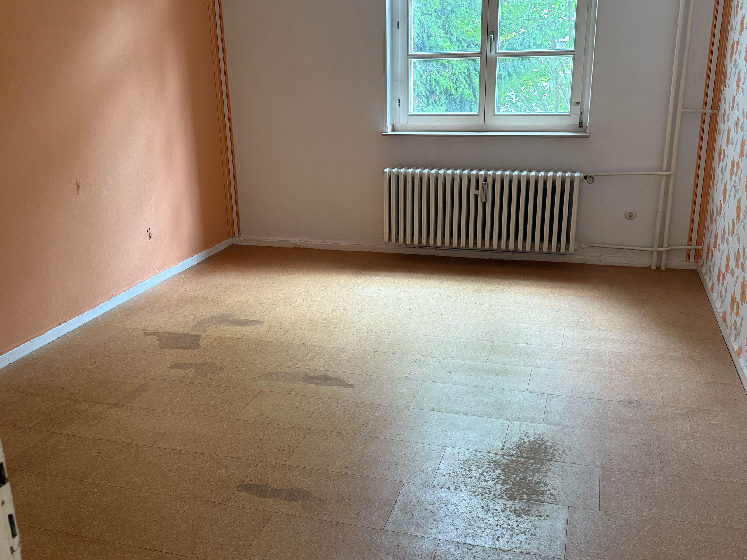 Leerer Wohnraum nach Entrümpelung mit Blick auf Fenster und Heizkörper - Haushaltsauflösung Paderborn